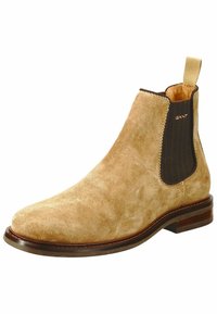 Beige Wildleder Chelsea-Boot mit dunklen elastischen Seitenpanelen und einem strukturierten Muster. Verfügt über eine abgerundete Zehenpartie und eine kontrastierende braune Sohle.