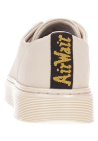 Light beige canvas shoe with a black fabric heel tab featuring "Airwalk" in yellow text. Detailed textured white rubber sole.