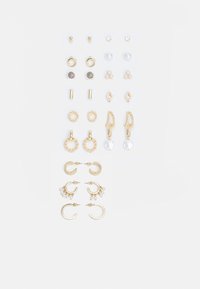 Ensemble de boucles d'oreilles en ton or comprenant divers designs, y compris des clous, des créoles et des pièces pendantes avec des perles et des strass.
