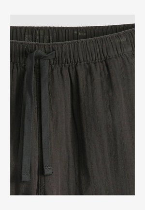 Zwarte elastische tailleband met verstelbare trekkoord, textuurstof, verticale strepen en een comfortabele pasvorm. Geschikt voor casual kleding.