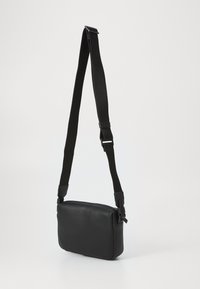 Sort syntetisk crossbody taske med en justerbar rem, rektangulær form, glat tekstur og minimalistisk design.