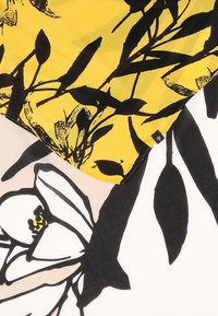 Tissu avec un fond jaune orné de motifs floraux noirs, superposé à un tissu rose pâle présentant un grand motif floral blanc avec des accents noirs.