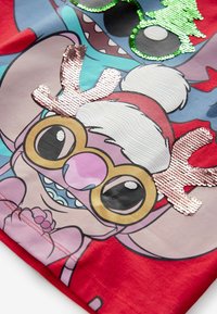 T-shirt di tessuto rosso con un personaggio dei cartoni animati e dettagli in paillettes rosa e verde. Il design presenta occhiali oversized e elementi festivi.