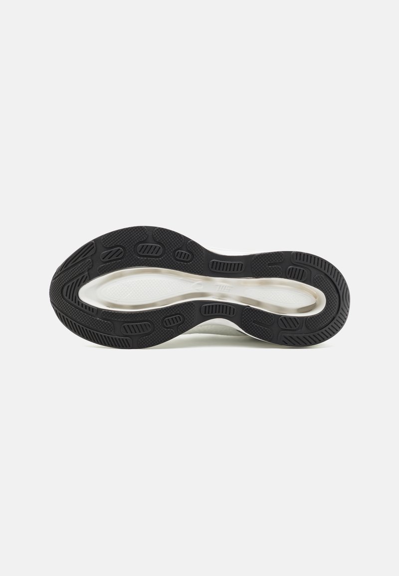 Suola di scarpa da ginnastica in bianco e nero caratterizzata da gomma testurizzata per una migliore aderenza, forma curvata e distintivi modelli di battistrada per una trazione migliorata.