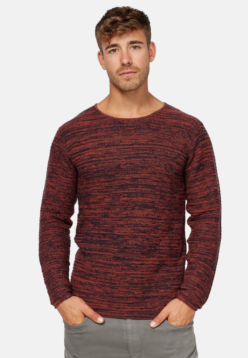 Pull à manches longues rayé rouge et noir avec un col rond et un motif en maille texturé. Tissu doux avec une coupe décontractée.