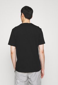 Czarny bawełniany t-shirt z krótkim rękawem i okrągłym dekoltem. Prosty design, gładki tył bez ozdób i grafik.