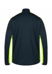 Maglia sportiva a maniche lunghe, blu navy scuro con pannelli laterali giallo brillante. Caratterizzata da un colletto alto e una texture liscia. Nessun marchio visibile.