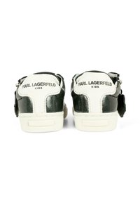 Czarno-białe trampki dziecięce z błyszczącymi czarnymi akcentami, teksturowanym wykończeniem i markowym tyłem. Posiadają zamek błyskawiczny i kontrastującą podeszwę.