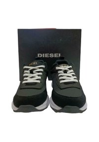 Schwarze Sportschuhe mit einem Obermaterial aus Mesh und Wildleder, weißen Schnürsenkeln, einem gepolsterten Kragen und einer Gummisohle. Box mit dem Aufdruck "DIESEL" in Schwarz.