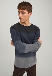 Langærmet crewneck skjorte med struktureret strik i mørkeblå og grå vandrette striber, med en kontrasterende solid sort overdel.