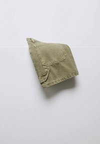 Olivengroene katoenen shirt, netjes gevouwen, met een enkele zak en subtiele stiksels. Soepele textuur, gestructureerde vorm.