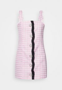 Robe courte en tartan rose avec bretelles à volants, bordure latérale noire, et boutons décoratifs ornés d'accents de perles au centre.