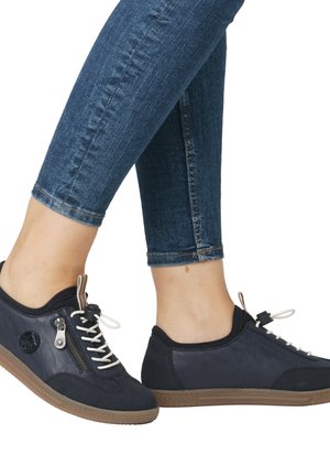Navy blue sports shoes with a suede and synthetic upper, featuring a side zipper, contrasting white laces, and a textured brown sole.
