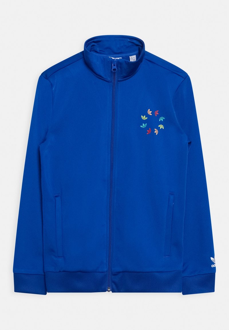 Veste zippée bleue avec col montant, poches latérales et un ensemble de logos multicolores sur la poitrine gauche, ainsi qu'un logo blanc sur le poignet droit.