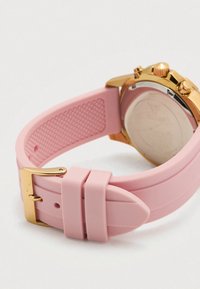 Ružičasta silikonska narukvica za sat sa kopčom u zlatnoj boji, teksturiranim unutarnjim dijelom i sjajnim zlatnim kućištem sata vidljivim s leđa.