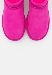 Stivaletti alla caviglia in suede rosa con una morbida fodera interna, punta arrotondata e cuciture a contrasto lungo la parte superiore. Suole piatte e flessibili per il massimo comfort.