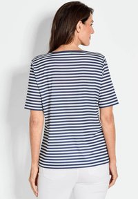 Marineblauwe en witte gestreepte korte mouwen t-shirt, zachte stof, relaxte pasvorm, ronde halslijn, achterkant zichtbaar met mouwlengte en streepjespatroon.