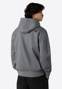 Grijze hooded sweatshirt met een logo op de bovenrug, met een losse pasvorm, lange mouwen en ribgebreide manchetten en zoom. Zachte textuur.