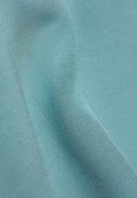 Tissu bleu clair lisse avec une fine texture côtelée horizontale et des plis souples créant des courbes et des ombres douces.