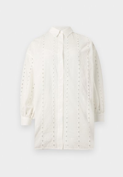 Hvid skjorte med lange ærmer og knapper, med lodrette striber af øjletsblonde, en krave og rynkede manchetter på en ensfarvet baggrund.