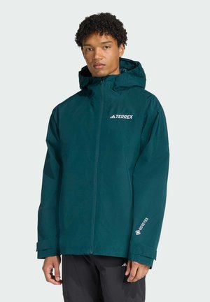 Teal hooded jacket made of lightweight, waterproof material. Features a front zipper, adjustable cuffs, and branded elements on the chest and sleeve.