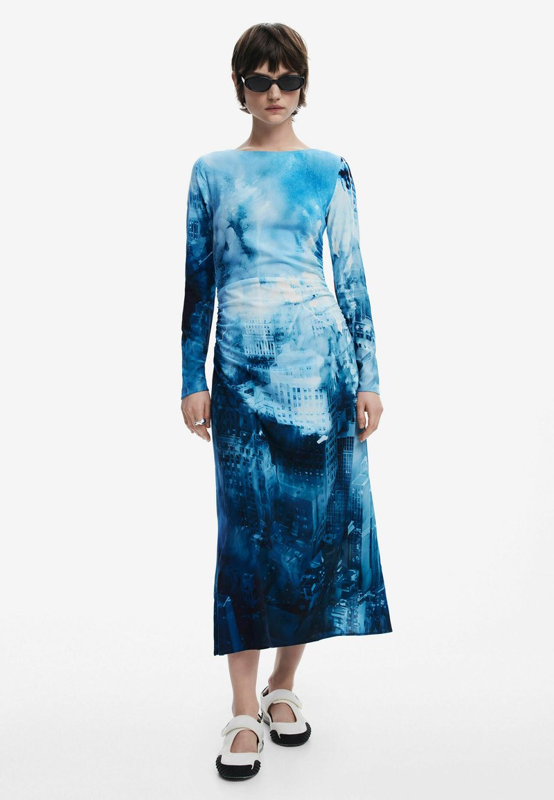 Haljina dugih rukava s plavim printom gradske pejzažne slike na glatkoj tkanini, dužine do sredine lista, s tijesnim oblikovanjem i suptilnim naborima.