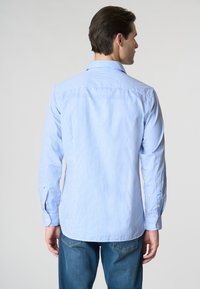 Camicia button-up a quadri blu chiaro con maniche lunghe e colletto classico, realizzata in tessuto tessuto, con orlo curvo e polsini abbottonati.