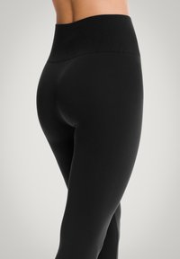 Leggings neri a vita alta con una texture liscia, dotati di un ampio elastico in vita e di una silhouette aderente che si adatta al corpo.