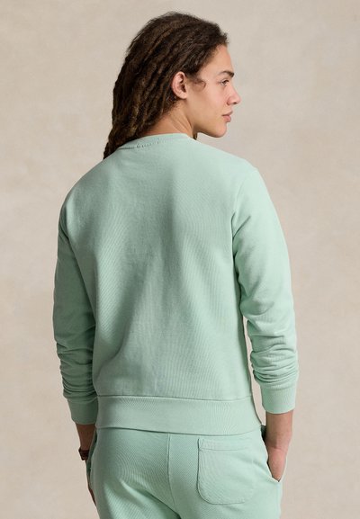 Sweatshirt verde claro feita de tecido macio, com gola redonda e punhos canelados, de corte descontraído e detalhes mínimos de costura.