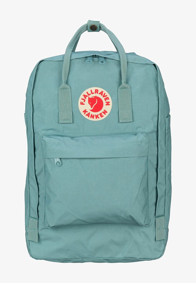 Bleu lichtblauwe Fjällräven Kanken rugzak heeft een rechthoekige vorm, een voorkant met ritsvak, twee zijvakken en een cirkelvormige logo patch.