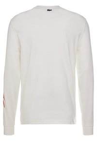 T-shirt bianco a maniche lunghe realizzato in cotone, con scollo a girocollo, polsini a coste e un piccolo logo verde sul retro. Accentazioni rosse sulle maniche.