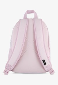 Rosa Rucksack mit gepolsterten, verstellbaren Trägern, Mesh-Details und einem oberen Griff. Enthält ein auffälliges Logo an der Seite. Glatte, strukturierte Oberfläche.