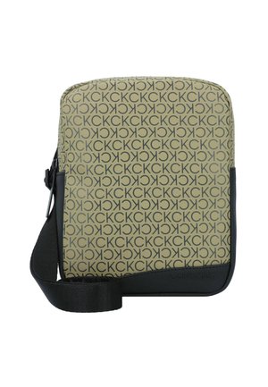 Bolso bandolera de Calvin Klein con fondo beige, estampado repetido de logo negro, ribete sintético negro y correa ajustable.
