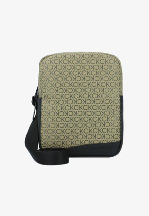 Sac bandoulière Calvin Klein avec un fond beige orné d'un motif répétitif du logo noir, une bordure synthétique noire et une sangle ajustable.