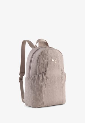 Helebeež tekstuuriga riidest seljakott reguleeritavate rihmadega ja väike metallist Puma logo eesmisel taskul.