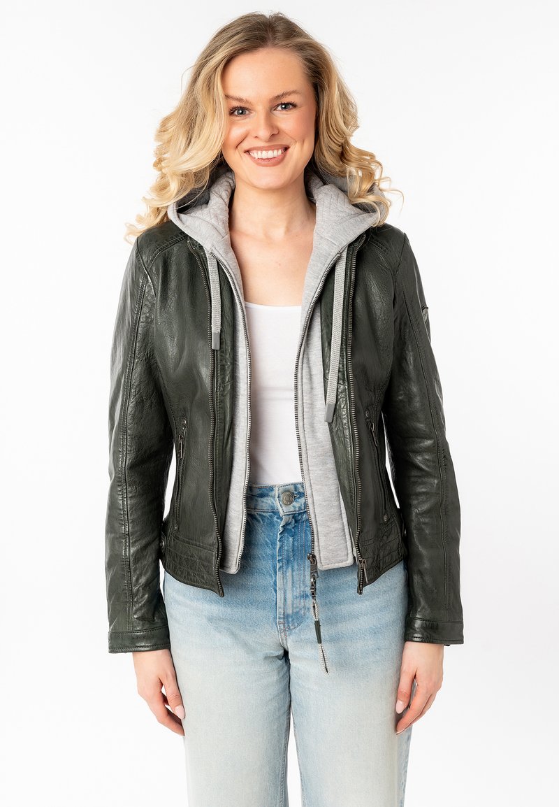 Groene leren jas met grijze hoodie, ritssluiting, twee zijzakken, getailleerd ontwerp, textuurafwerking, gedragen over een witte top en lichtblauwe jeans.