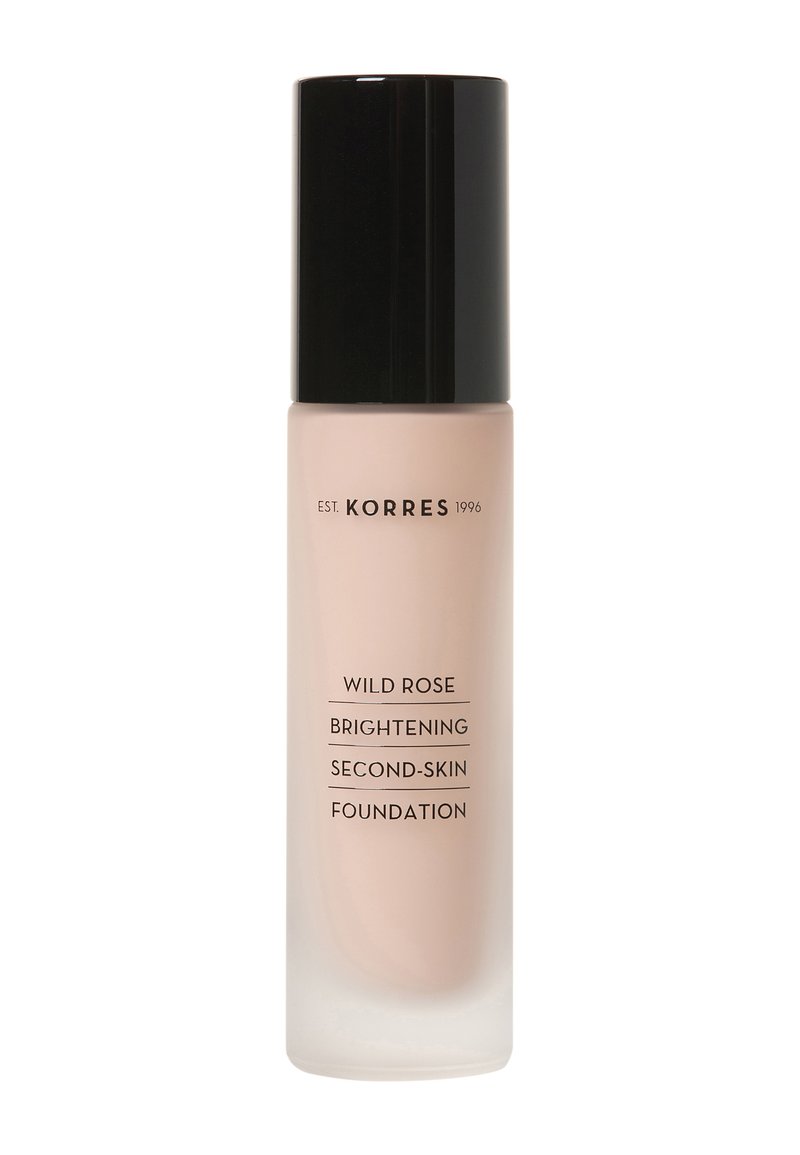 Fond de teint illuminant seconde peau Wild Rose de Korres dans un flacon en verre transparent. Il présente un capuchon noir brillant et un liquide beige neutre à l'intérieur.