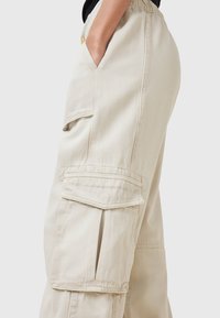 Beige cargobroek van katoen, met zijzakken, een relaxte pasvorm en zichtbare stikseldetails voor extra textuur.
