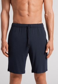 Marineblaue Shorts mit elastischem Bund und Kordelzug sowie subtiler Schimmerung. Schlichtes Design, glatte Textur und knielanger Schnitt.