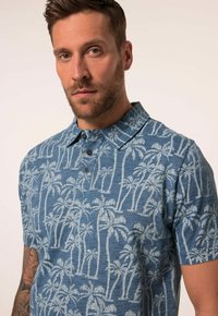 Kortärmad skjorta med krage i blekblått tyg som har ett mönster av palmer, med kontrasterande knappar och en strukturerad finish.