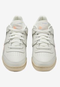 Sneakers bianchi in pelle con punta tonda, doppio laccio, punta perforata e morbidi accenti pesca sui lati. Suola testurizzata per una migliore aderenza.