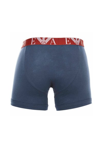 Marineblauwe bokser shorts met een rode tailleband, voorzien van witte merklettering en logo. Zachte stof en een aansluitend ontwerp met soepele naden.