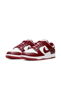 Nike sneakers featuring a white leather upper with maroon leather accents, perforated toe box, flat maroon laces, and rubber outsole.