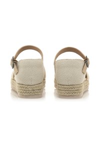 Zapatos de espadrilles beige con parte superior de tela trenzada, acabado texturizado y suela de cuerda de yute. Incluyen una correa ajustable en el tobillo.
