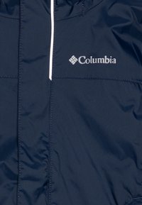 Námořnická modrá bunda Columbia s předním zipem, elastickou kapucí a lehkým švem; obsahuje kovový logo na hrudi.