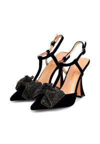 Sandalias de tacón alto de ante negro con punta afilada, con un gran lazo decorado y una correa en el tobillo con un hebilla plateada.