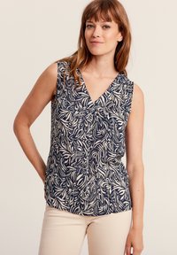 Blusa senza maniche blu navy con scollatura a V, caratterizzata da un motivo foglia astratto bianco. Tessuto morbido con una vestibilità comoda, che termina all'anca.