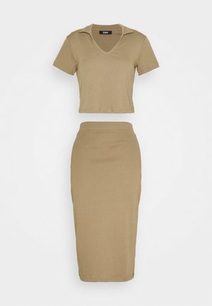 Beżowy dwuczęściowy strój z krótkim, dopasowanym topem z kołnierzykiem i ołówkową spódnicą o długości do kolan z wysokim stanem.