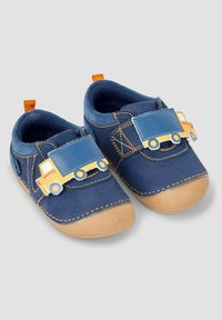 Marinblåa barnskor med kardborreband, prydda med en lastbilsmotiv. Materialet är mjukt tyg med en gummisula, detaljerad söm och orangea accenter.
