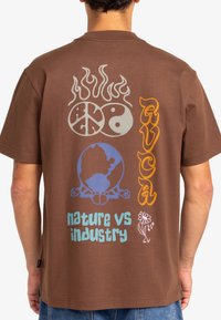 Brown cotton t-shirt featuring colorful graphic designs on the back, including flames, peace symbol, globe, and text "nature vs industry."